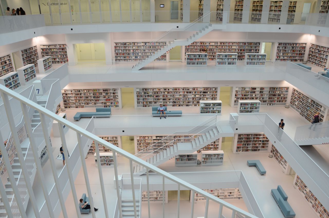 Home Contemporary library interior featuring white staircases and bookshelves, showcasing modern architecture.